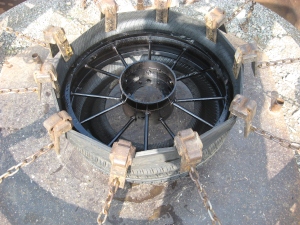 Fixture for stretching rubber tires around solid metal rimmed wheels at Pioneer 